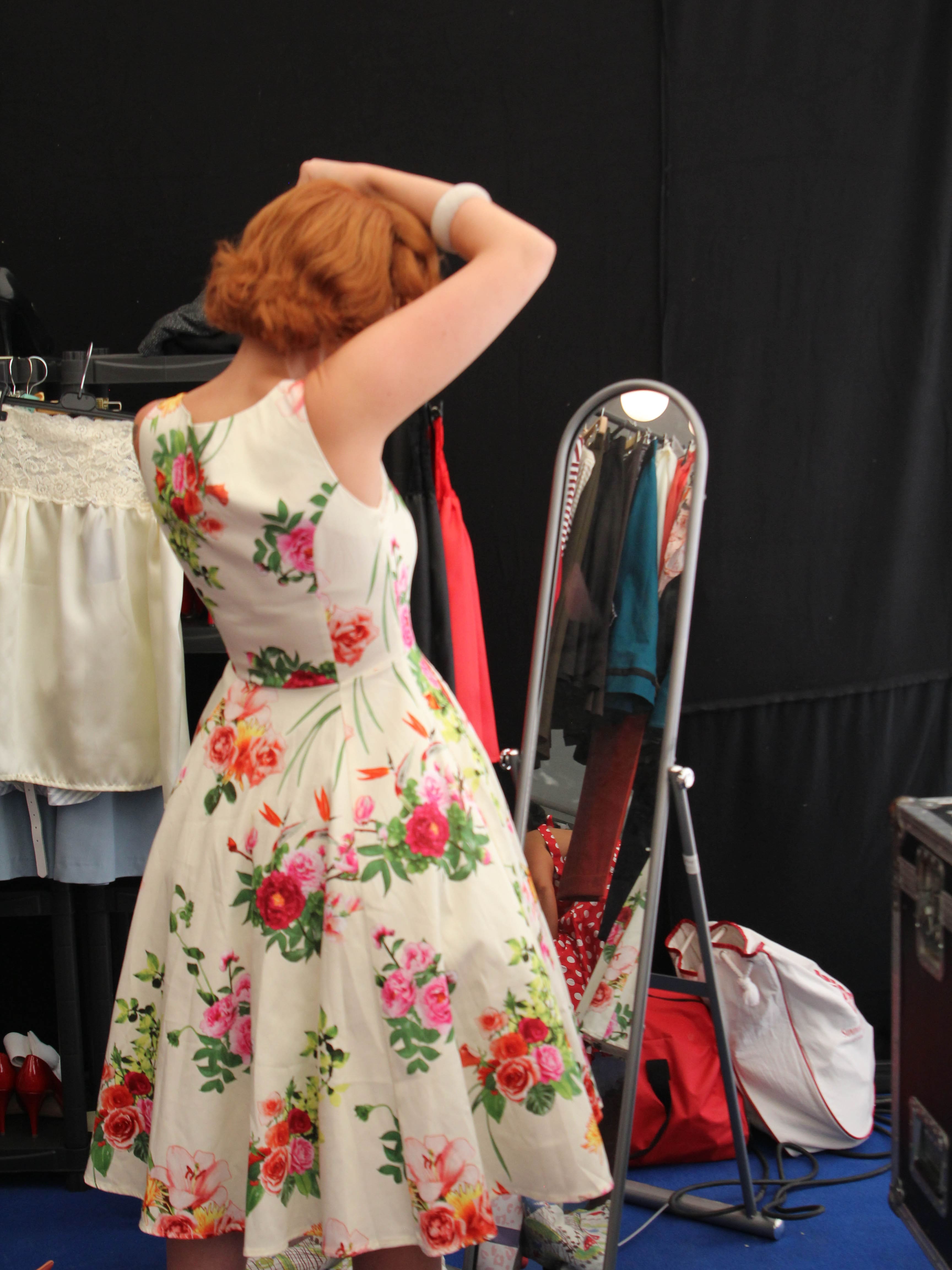 Frau in Vintagekleid vor Spiegel