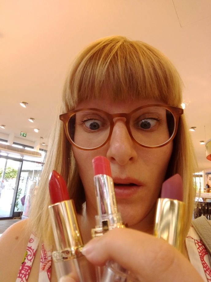 Frau verzweifelt mit vielen Lippenstiften